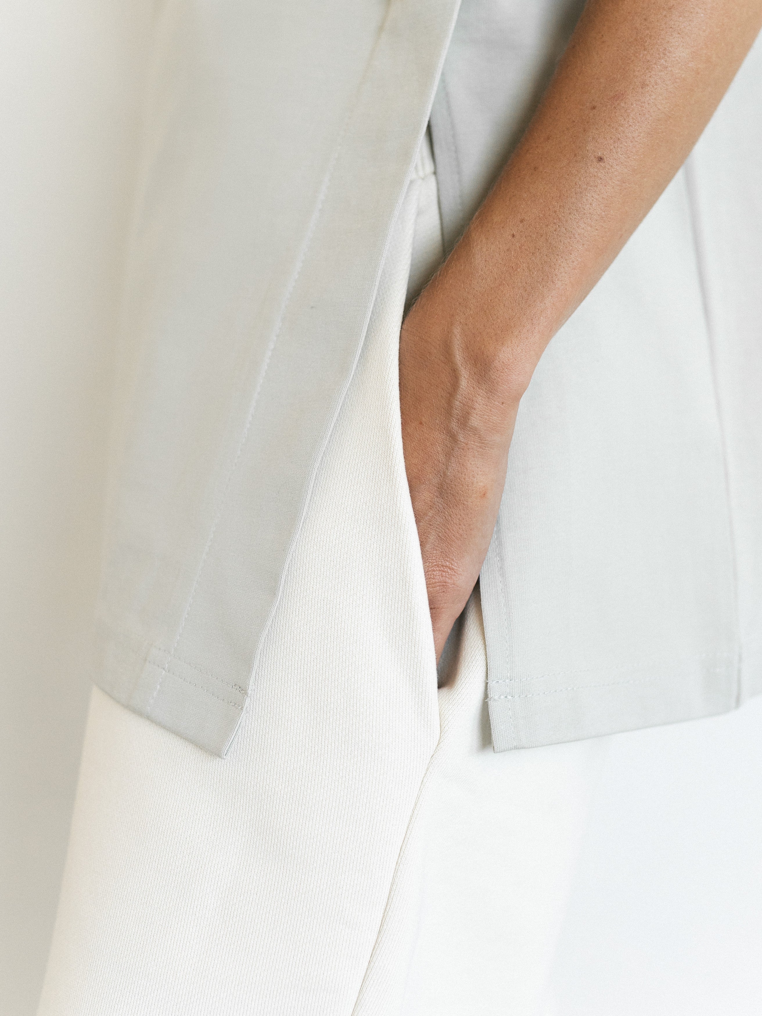 Close-up of The Ultimate Tee in Dawn showing the slits at the hem, providing a better fit during pregnancy. These slits enhance comfort and allow for versatile styling, making it the perfect maternity tee | amama.shop