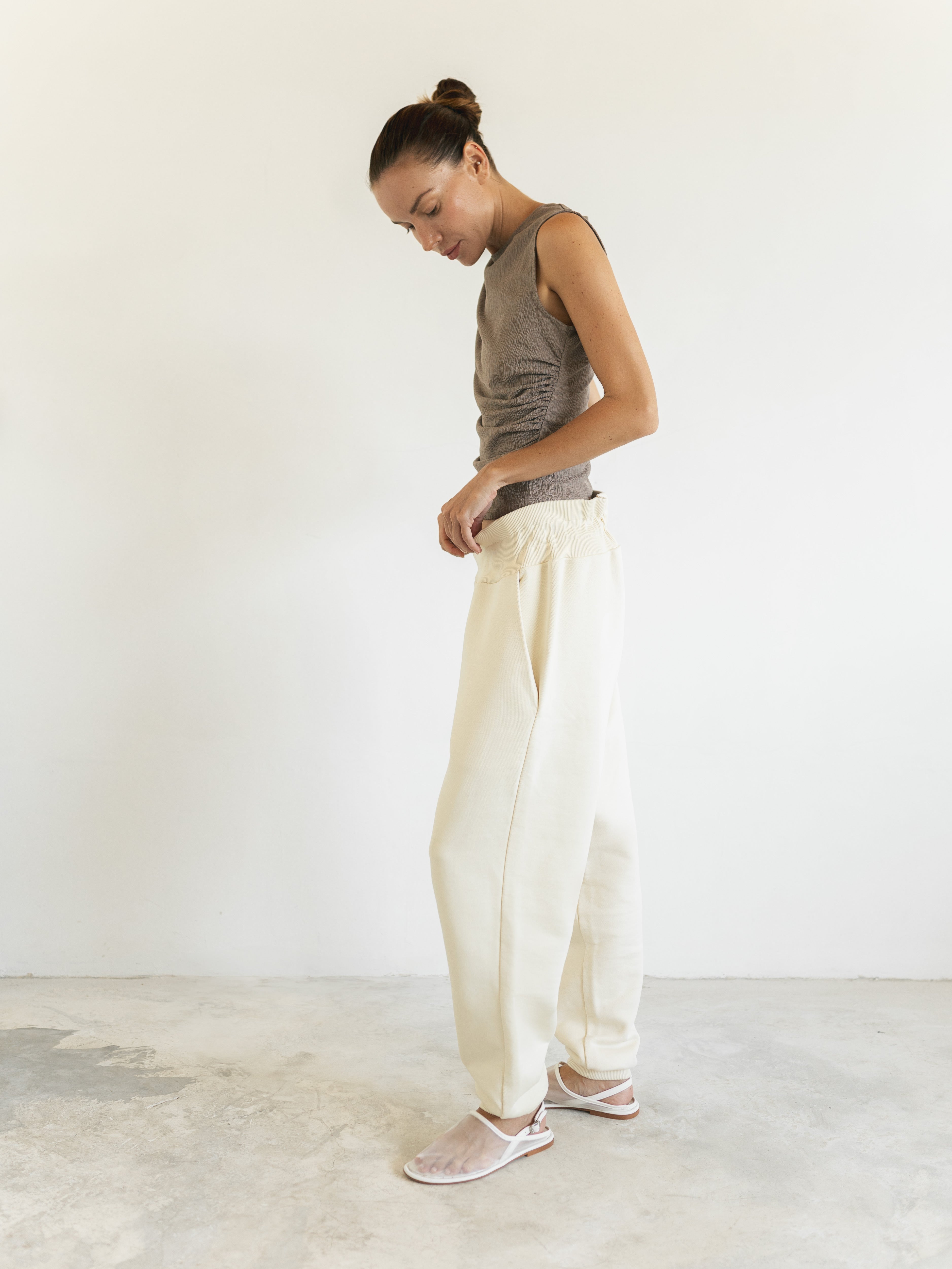 Side view of The Optimal Jogger in Sun Sparkle, featuring a relaxed fit for comfortable maternity wear. Its unique combination of shape, fabric texture, and a natural and sophisticated shade elevates it beyond the ordinary | shop online | amama.shop